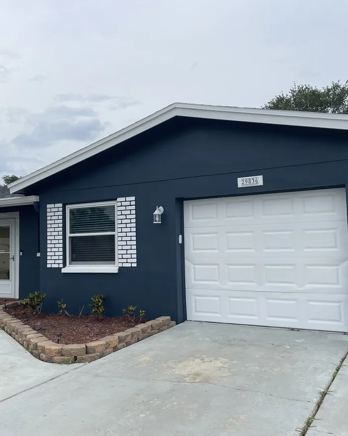 Single story home repainted in warm cream with white trim and a clean garage door