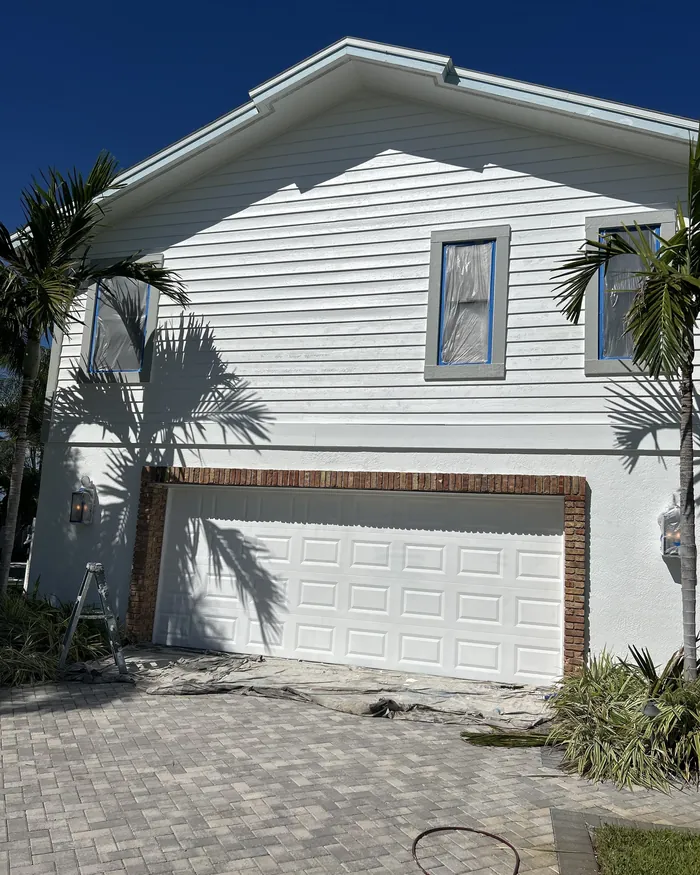 Two story house repainted with straight cut lines at the fascia and dark trim on the windows